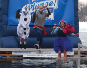 Three people dressed as Olaf, Kristoff and Anna are seen mid-leap as they participate in the plunge.
